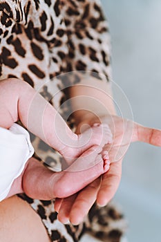 Baby feet in mother hands. Tiny Newborn Baby feet on female hands close up. Mom and her child. Care, Happy Family