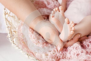 Baby feet in mother hands. Tiny newborn baby`s feet on female hands closeup. Mom and her child. Happy Family concept. Beautiful