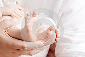 Baby feet in mother hands. Tiny newborn baby`s feet on female hands closeup. Mom and her child. Happy Family concept. Beautiful