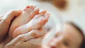 Baby feet in mother hands. Tiny Newborn Baby`s feet on female Heart Shaped hands closeup. Mom and her Child. Happy Family concept.