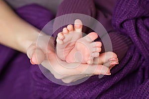 Baby feet in mother hands. Tiny Newborn Baby's feet on female Shaped hands closeup.