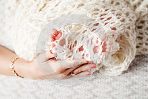 Baby feet in mother hands. Tiny newborn baby`s feet on female shaped hands closeup. Mom and her child.  Beautiful conceptual imag