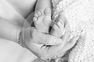 Baby feet in mother hands. Tiny newborn baby`s feet on female shaped hands closeup. Mom and her child. Beautiful conceptual image