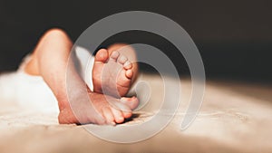 Baby feet in mother hands. Tiny Newborn Baby`s feet on female Shaped hands closeup. Mom and her Child. Happy Family