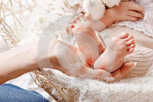 Baby feet in mother hands. Tiny Newborn Baby`s feet on female Shaped hands closeup. Mom and her Child. Happy Family concept.