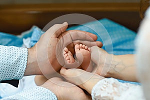 Baby feet in mother hands, tiny newborn baby`s feet on female shaped hands closeup, mom and her child, happy family concept, beau