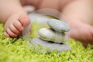 Baby feet next to stack of zen stones