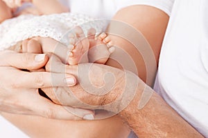 Baby feet in parents hands. Tiny Newborn Baby`s feet on parents.on white background