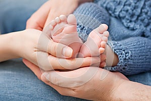 Baby feet in parents hands. Tiny Newborn Baby's feet