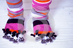 Baby feet in warm, long multicolored socks with toes