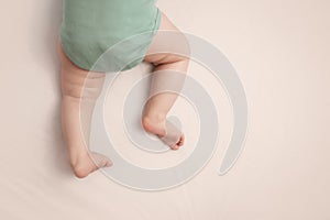 Sleeping baby feet on white background in bed