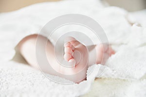 Baby feet on white coverlet. Toes