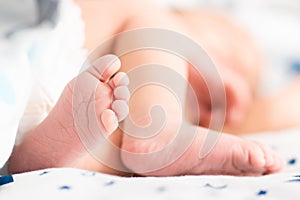 Baby feet on white coverlet. Toes. Horizontal photo.