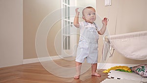 Baby first steps. Son a baby toddler learning to walk take first steps. Happy family kid dream concept. Baby indoors