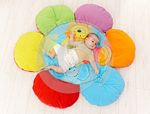 Baby on flower playmat photo
