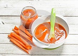 Baby food. Baby puree from fresh carrots with a spoon.