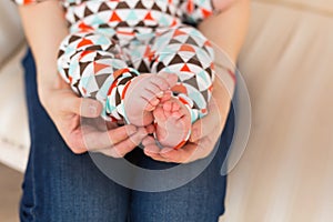 Baby foot in female hands, close-up. Cute little kid leg. Maternity, love, care, new life concept