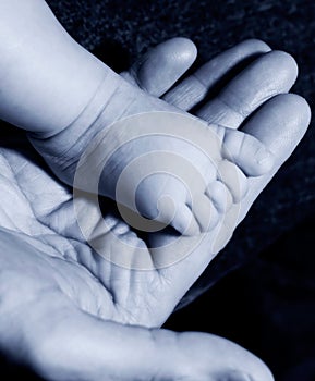Baby foot on mans hand