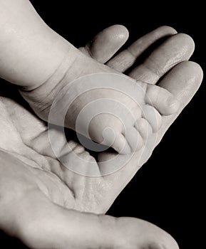 Un nino pierna sobre el mano en blanco y negro 