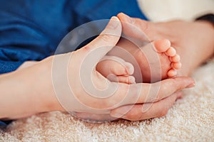 Baby foot in mother hands.