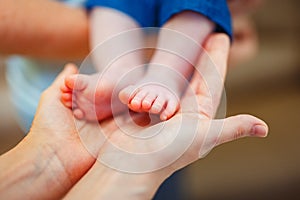 Baby foot in mother hands.