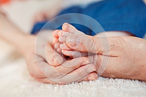 Baby foot in mother hands.