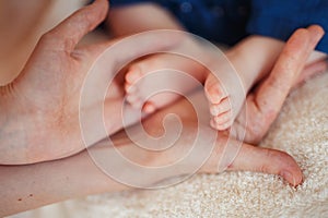 Baby foot in mother hands.