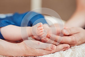 Baby foot in mother hands.