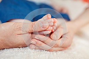 Baby foot in mother hands.