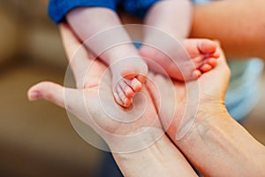 Baby foot in mother hands.