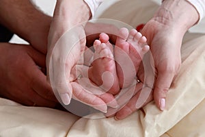 Baby foot in mother`s hands with care