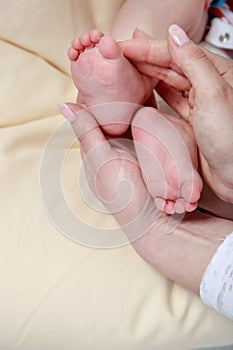 Baby foot in mother`s hands with care