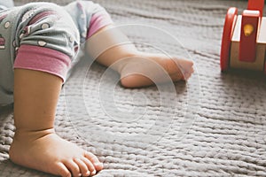 Baby foot and red toy on the bed