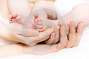Baby foots in hands of parents photo
