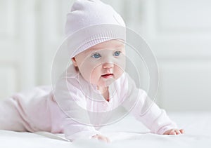 Baby girl with big blue eyes on white blanket