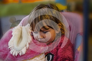 Baby girl with blond hair sitting on swing