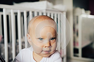 Baby girl with blue eyes and blond hair is smiling