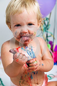 Baby girl celebrating her first bithday with gourmet cake and ba