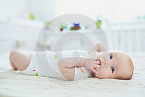 Baby girl in co-sleeper attached to parents` bed