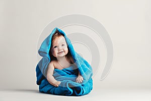 Baby girl covered with a blue warm blanket