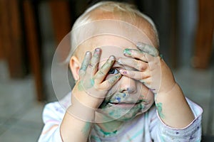 Baby Girl COvering Messy Face with Little Hands