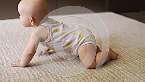 Baby girl crawling on all fours on floor at home