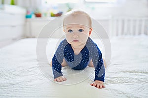 Baby girl crawling on bed