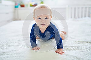 Baby girl crawling on bed