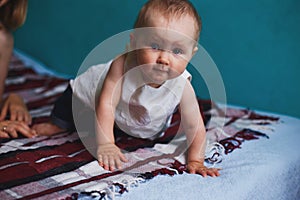 Baby girl crawling at bed in living room