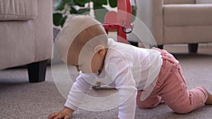Baby girl crawling in living room