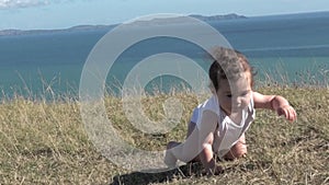 Baby girl crawling outdoors.