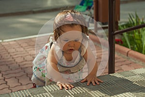 Baby girl crawling up the stairs. High angle view