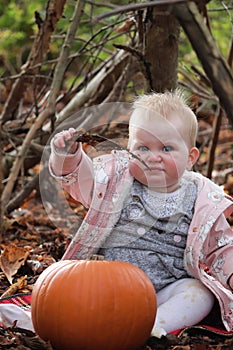 Baby girl cute face blonde hair in autumn leaves during holiday season