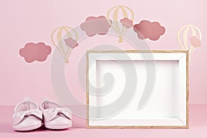 Baby girl cute pink shoes over the pink pastel background with clouds and ballons